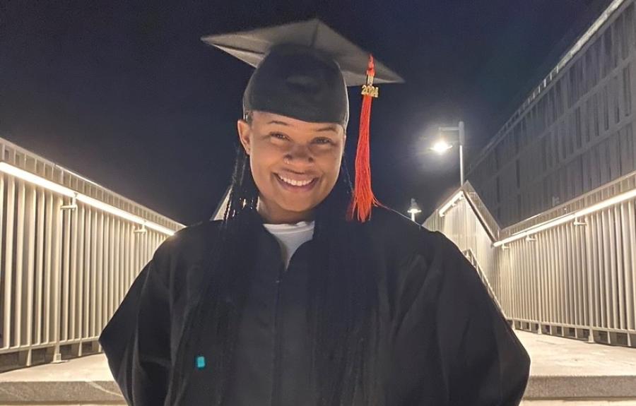 A smiling college student in a cap and gown.